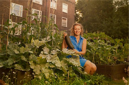 private garden - Young woman harvesting marrows on council estate allotment Stock Photo - Premium Royalty-Free, Code: 649-07280543
