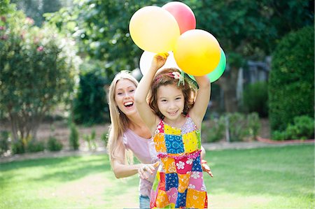 family and happy and outside and play - Mother and daughter in garden with balloons Stock Photo - Premium Royalty-Free, Code: 649-07280604