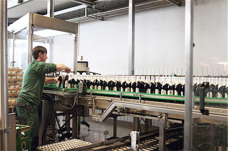 Brewery worker operating bottling machine Foto de stock - Sin royalties Premium, Código: 649-07280640