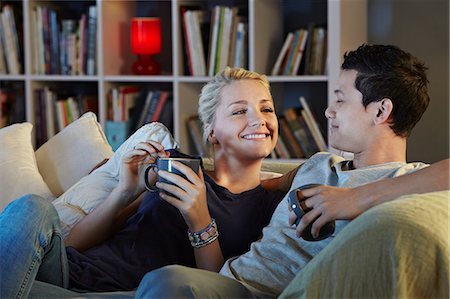Young couple sitting on sofa with hot drinks Stock Photo - Premium Royalty-Free, Code: 649-07280698