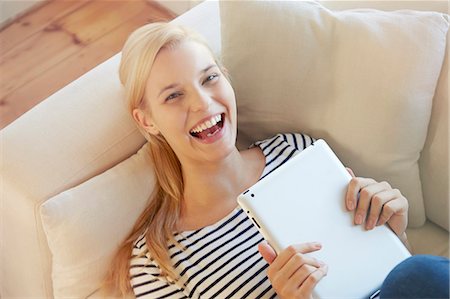 Young woman on sofa, using digital tablet Stock Photo - Premium Royalty-Free, Code: 649-07280729