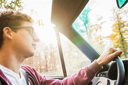 simsearch:649-08125542,k - Young man leaning driving convertible on country road Photographie de stock - Premium Libres de Droits, Code: 649-07280823