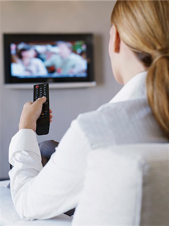 sitting on couch from back - Young woman watching television in hotel room Stock Photo - Premium Royalty-Free, Code: 649-07280830