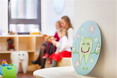 sanidad - Family in dentists waiting room, picture of tooth in foreground Foto de stock - Sin royalties Premium, Código: 649-07280840