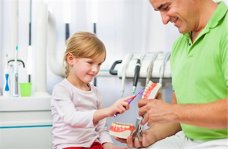 dental kids - Dentist teaching girl how to brush teeth Stock Photo - Premium Royalty-Free, Code: 649-07280854