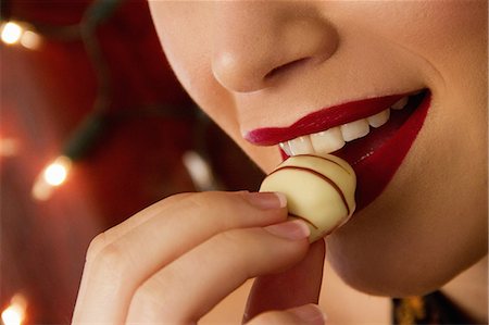 sweet treats - Cropped close up of young woman eating chocolate Stock Photo - Premium Royalty-Free, Code: 649-07280908