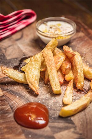 Still life of potato fries, ketchup and dip Foto de stock - Royalty Free Premium, Número: 649-07280922