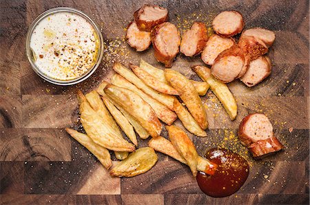 foods for dip - Still life of potato fries, ketchup and currywurst Stock Photo - Premium Royalty-Free, Code: 649-07280923