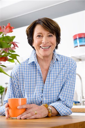 senior adults blue shirts - Portrait of youthful senior woman in kitchen Stock Photo - Premium Royalty-Free, Code: 649-07280936