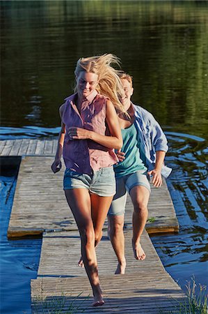 simsearch:649-09111261,k - Young adult couple running on pier, Gavle, Sweden Stock Photo - Premium Royalty-Free, Code: 649-07280959