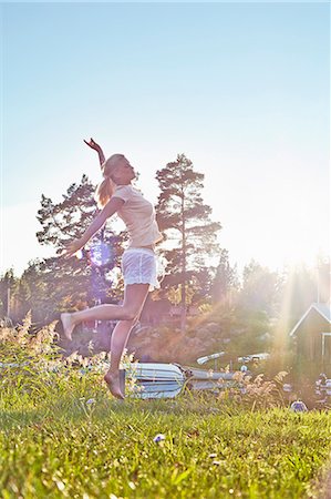 summer fun - Young woman leaping next to lake, Gavle, Sweden Stock Photo - Premium Royalty-Free, Code: 649-07280976