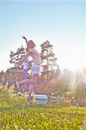 summers day - Young woman leaping next to lake, Gavle, Sweden Stock Photo - Premium Royalty-Free, Code: 649-07280976