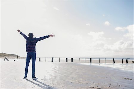 freiheit - Young man standing on beach with arms out, Brean Sands, Somerset, England Stockbilder - Premium RF Lizenzfrei, Bildnummer: 649-07281011