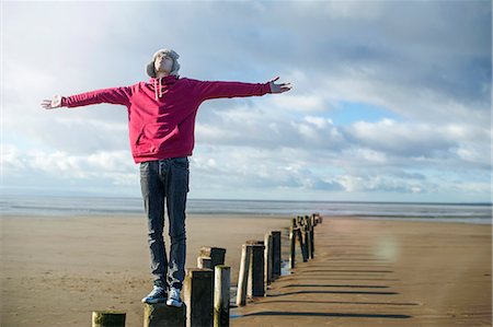 england outdoors one person - Young man standing on groynes, Brean Sands, Somerset, England Stock Photo - Premium Royalty-Free, Code: 649-07281026