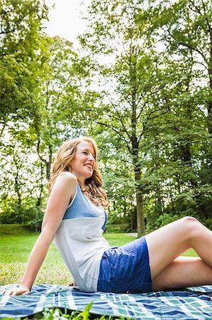 simsearch:649-07436300,k - Young woman sitting on picnic blanket in park Foto de stock - Sin royalties Premium, Código: 649-07436289