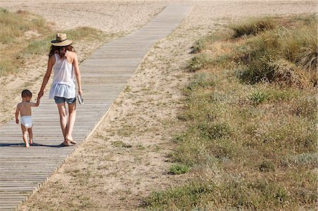 diapers - Rear view of mother and son walking down boardwalk to beach Photographie de stock - Premium Libres de Droits, Code: 649-07436380