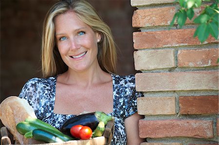 Mature woman standing outside with basket of organic food Stock Photo - Premium Royalty-Free, Code: 649-07436485