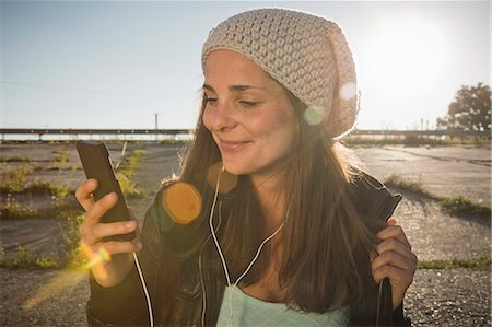 evening sun - Young woman wearing earphones listening to music Photographie de stock - Premium Libres de Droits, Code: 649-07436670