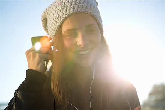 Portrait of young woman wearing earphones listening to music Stock Photo - Premium Royalty-Free, Image code: 649-07436671