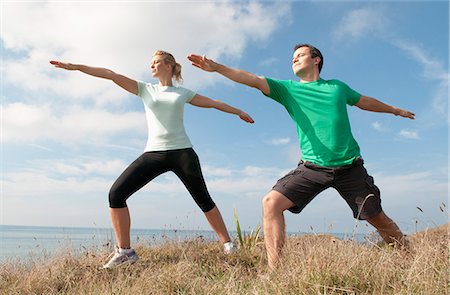stretching (people exercising) - Mid adult couple exercising on cliff top, Thurlestone, Devon, UK Stock Photo - Premium Royalty-Free, Code: 649-07436706