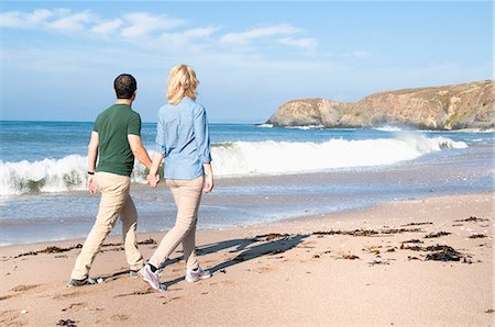 Mid adult couple walking on beach, Thurlestone, Devon, UK Stock Photo - Premium Royalty-Free, Code: 649-07436701