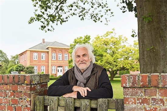 Senior man leaning on wooden gate Stock Photo - Premium Royalty-Free, Image code: 649-07436777
