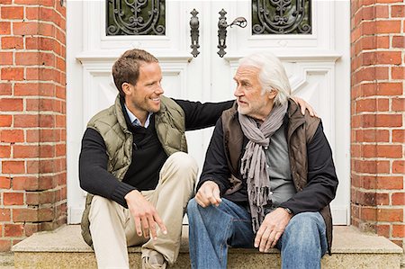 father and older son and two people - Father and son sitting on doorstep Foto de stock - Sin royalties Premium, Código: 649-07436773