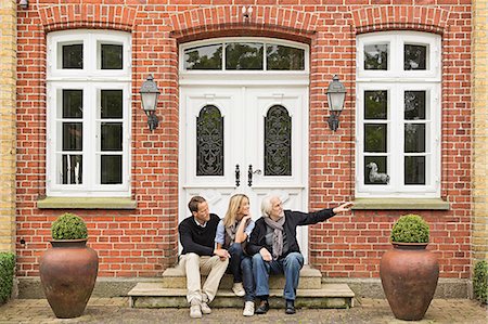 front door - Father and mid adult couple sitting on doorstep Stock Photo - Premium Royalty-Free, Code: 649-07436796