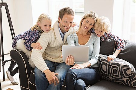 Parents with two children using digital tablet Photographie de stock - Premium Libres de Droits, Code: 649-07436834