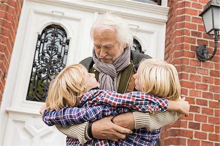 entrada - Grandfather hugging grandchildren by front door Foto de stock - Sin royalties Premium, Código: 649-07436843