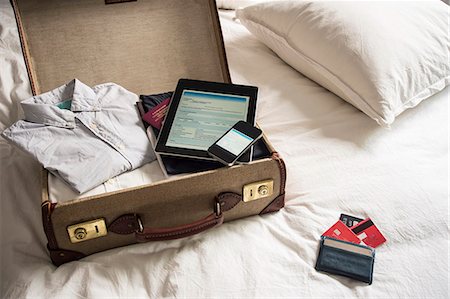 Open suitcase on bed with digital tablet and mobile phone Stock Photo - Premium Royalty-Free, Code: 649-07437012
