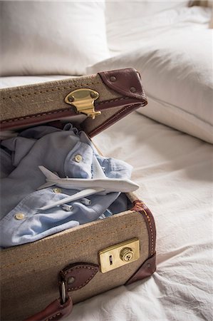 packing for travel - Open suitcase on bed with shirt and toy airplane Stock Photo - Premium Royalty-Free, Code: 649-07437013