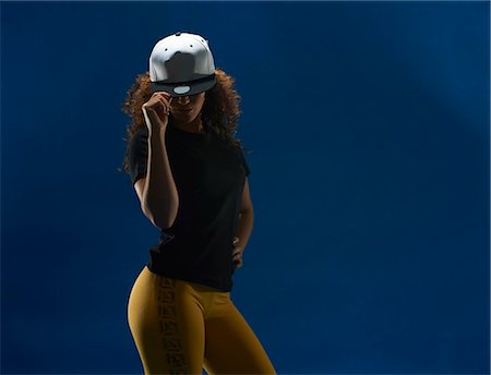 simsearch:649-07437435,k - Studio portrait of young woman tipping her baseball cap Stock Photo - Premium Royalty-Free, Code: 649-07437159