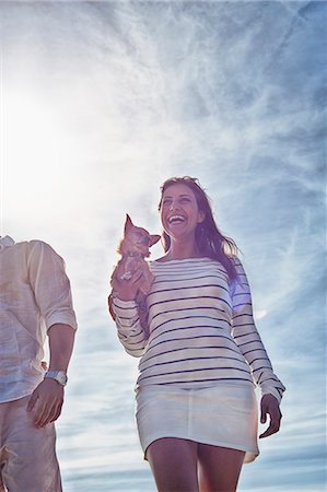 Young woman holding dog, low angle view Stock Photo - Premium Royalty-Free, Code: 649-07437183