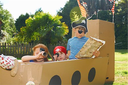 Two brothers and sister playing with homemade pirate ship in garden Stock Photo - Premium Royalty-Free, Code: 649-07437208