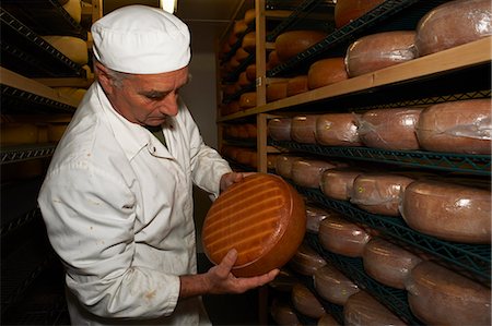 Senior man checking cheese round at farm factory Stock Photo - Premium Royalty-Free, Code: 649-07437202