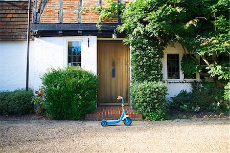 patinette - Toy scooter parked outside cottage Photographie de stock - Premium Libres de Droits, Code: 649-07437211