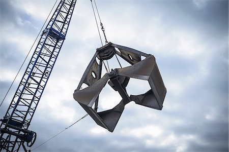 Low angle view of crane grab against cloudy sky Stock Photo - Premium Royalty-Free, Code: 649-07437243