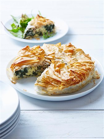 phyllo pastry - Still life of spanakopita with sliced portion Stock Photo - Premium Royalty-Free, Code: 649-07437284