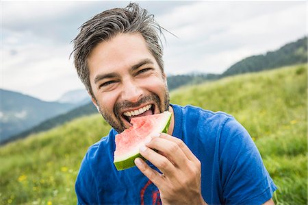 red watermelon - Man biting into watermelon Stock Photo - Premium Royalty-Free, Code: 649-07437368