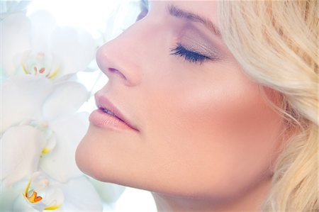 Close up of woman smelling orchids Stock Photo - Premium Royalty-Free, Code: 649-07437373