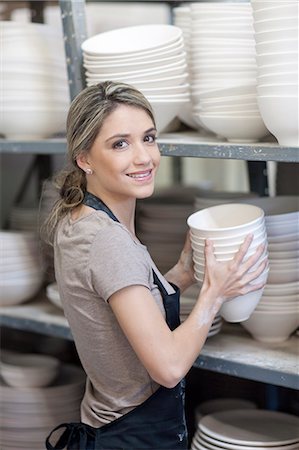 simsearch:649-07437453,k - Potter stacking bowls onto shelf at crockery factory Stock Photo - Premium Royalty-Free, Code: 649-07437448