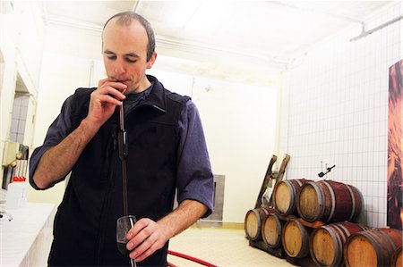 single man drinking wine - Wine maker tasting wine in industrial wine cellar Stock Photo - Premium Royalty-Free, Code: 649-07437498