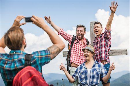 Young man photographing friends by cross Foto de stock - Sin royalties Premium, Código: 649-07437598