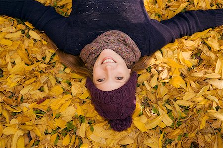 fall outside fun - Young woman lying in autumn leaves Stock Photo - Premium Royalty-Free, Code: 649-07437631