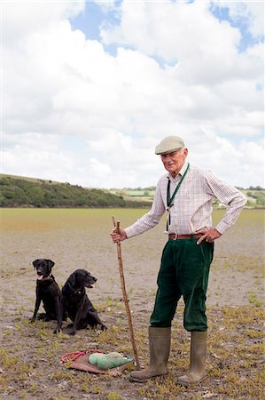 senior man in rubber boots - Portrait of senior man with two black labradors Stock Photo - Premium Royalty-Free, Code: 649-07437708