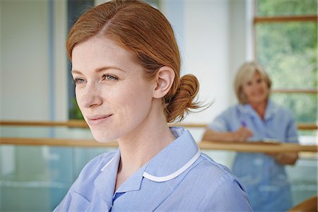 Two female nurses on hospital atrium balcony Stock Photo - Premium Royalty-Free, Code: 649-07437703