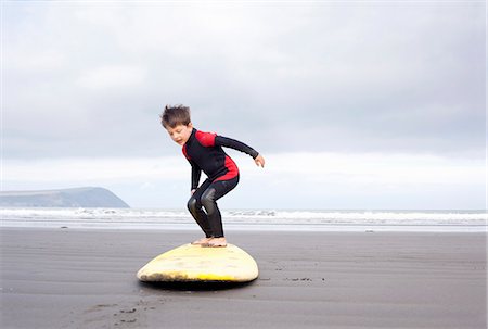 Boy practising on surfboard on beach Stockbilder - Premium RF Lizenzfrei, Bildnummer: 649-07437736