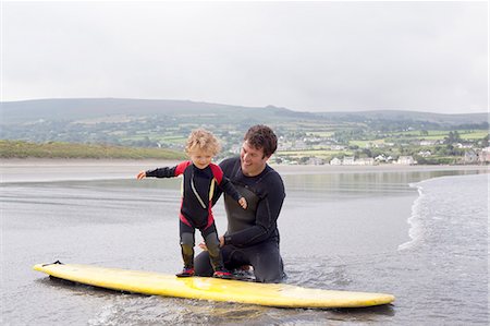 surf boards - Father teaching son how to surf Foto de stock - Sin royalties Premium, Código: 649-07437742