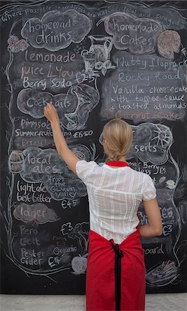 simsearch:649-07436665,k - Waitress writing on blackboard menu in cafe Fotografie stock - Premium Royalty-Free, Codice: 649-07437827